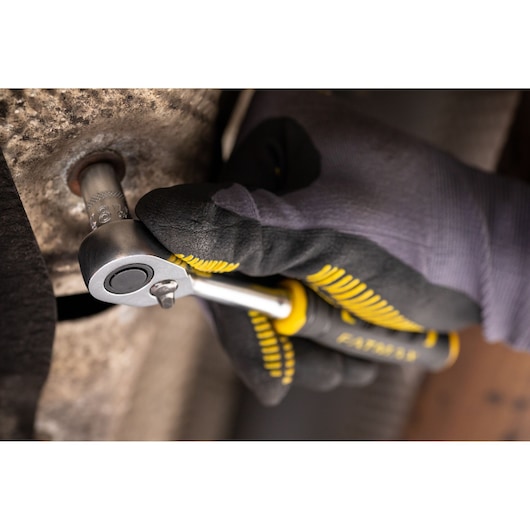 Photo of STANLEY FMMT17187-0 ratchet handled by gloved hand tightening a bolt, close-up view.