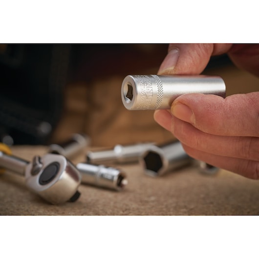 STANLEY FMMT17248-0 socket held in hand, close-up with other sockets and ratchet on work surface.