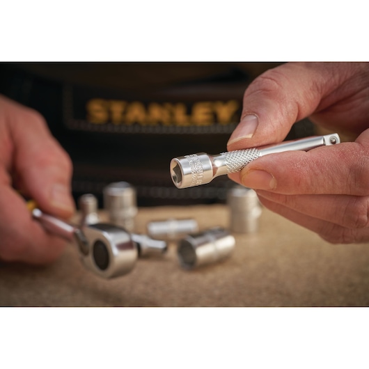 Photo of STANLEY FMMT25125-0 socket wrench and attachment held in hand with other sockets nearby.