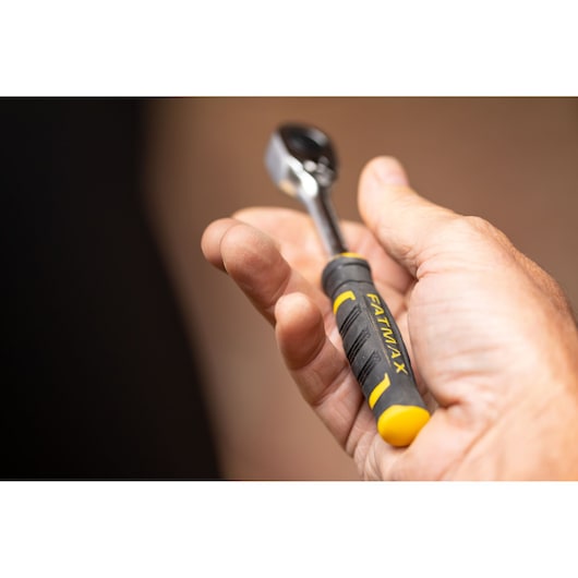 STANLEY FMMT82679-0 ratchet with black and yellow FATMAX handle held in hand, close-up photo.