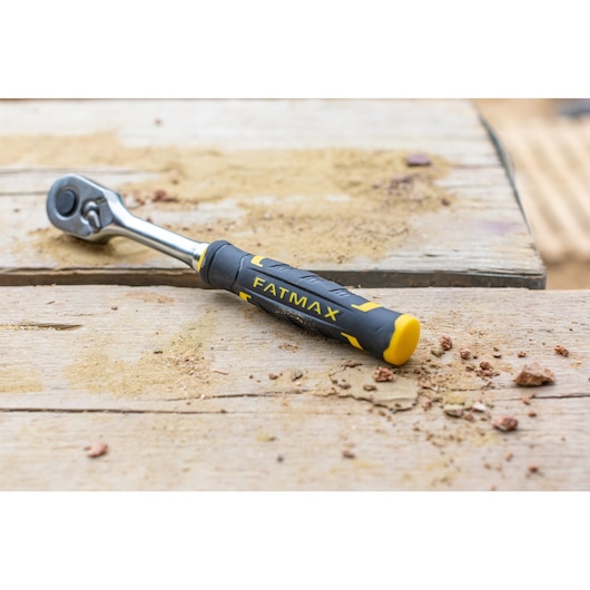 STANLEY FMMT82680-0 ratchet wrench with black and yellow FATMAX handle on a dusty wooden surface.