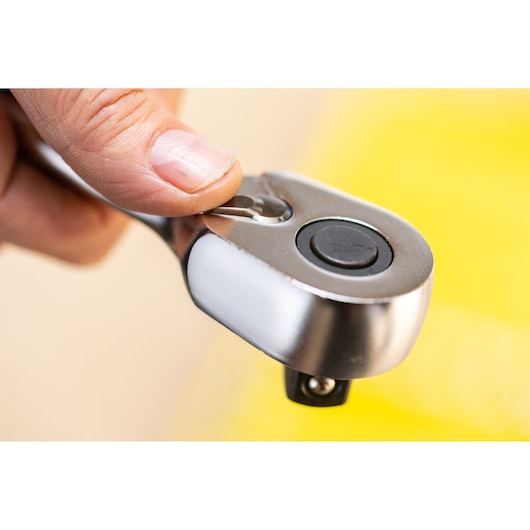 Photo of STANLEY FMMT82681-0 ratchet handle used by hand, close-up on tool head and button.