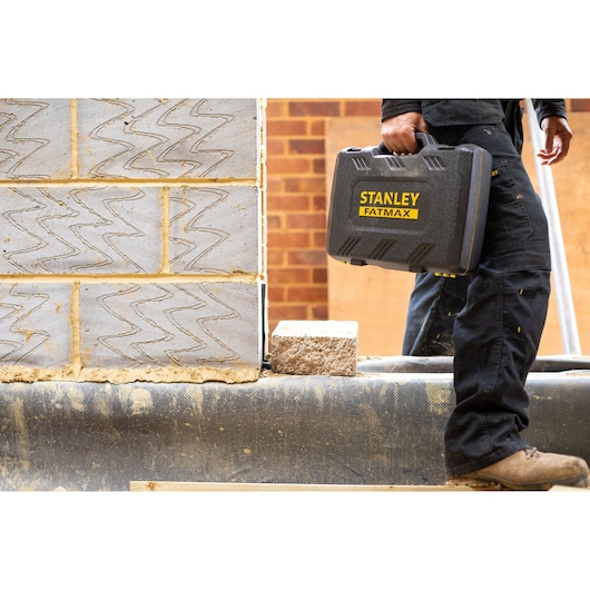 Stanley FMMT82685-1 tool case with Fatmax branding, held by worker at construction site.