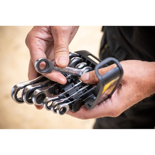 STANLEY FMMT82900-0 ratcheting combination wrench set held in hands, close-up outdoor view.
