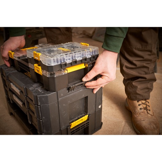 STANLEY FMMT98101-0 photography of modular black and yellow toolboxes being latched together from a side angle.