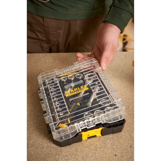 Photo of STANLEY FMMT98102-0 ratchet socket set in clear plastic case on workbench.