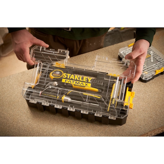 STANLEY FMMT98106-1 toolkit with transparent lid on workbench, featuring yellow and black hand tools.