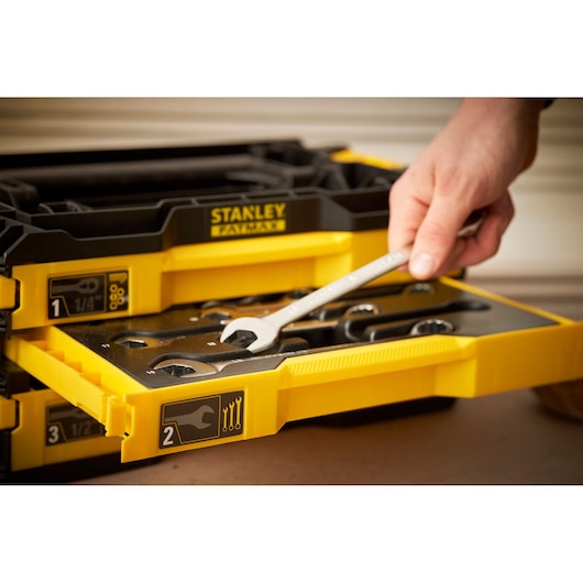 Photo of STANLEY FMMT98107-1 tool drawer with hand holding wrench, yellow and black organizer.