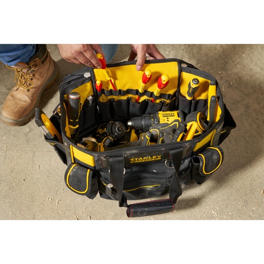 STANLEY FMST1-70749 tool bag top view with assorted hand tools and power tools, black and yellow fabric.
