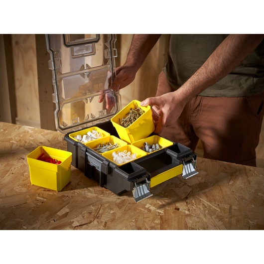 STANLEY FMST1-72378 organiser box with yellow removable bins, filled with assorted hardware, photo at tabletop angle.