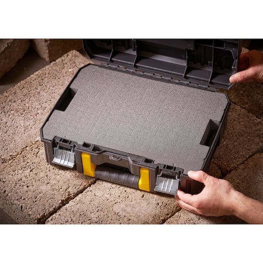 STANLEY FMST1-75502 foam-filled black tool case with yellow accents, open, shown on stone surface.