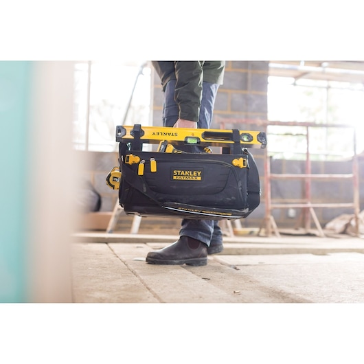 Photo of STANLEY FMST1-80146 FATMAX tool bag with yellow tools on a construction site.