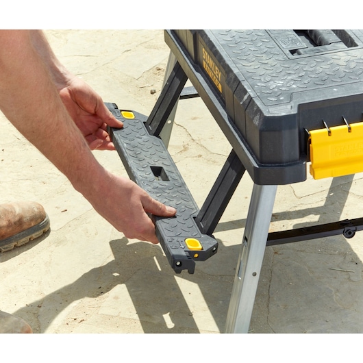 STANLEY FMST81083-1 portable workbench with textured surface and removable support, outdoor setting.