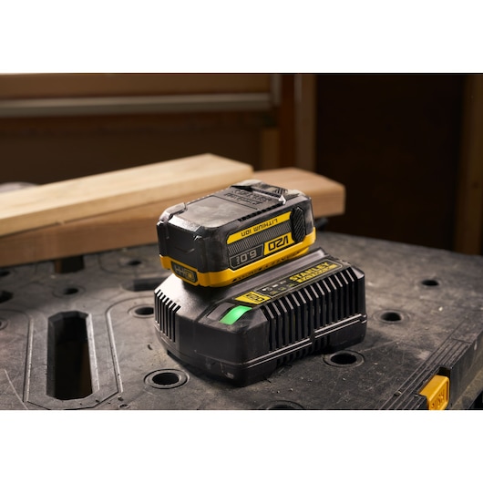 Stanley SFMCB206 lithium-ion battery and charger on a workbench, photography angled from the front side.