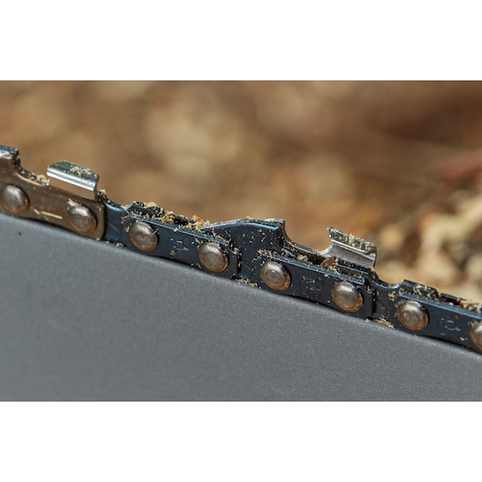 STANLEY SFMCCS630B chainsaw close-up, showing metal chain teeth and cutting edges with sawdust.