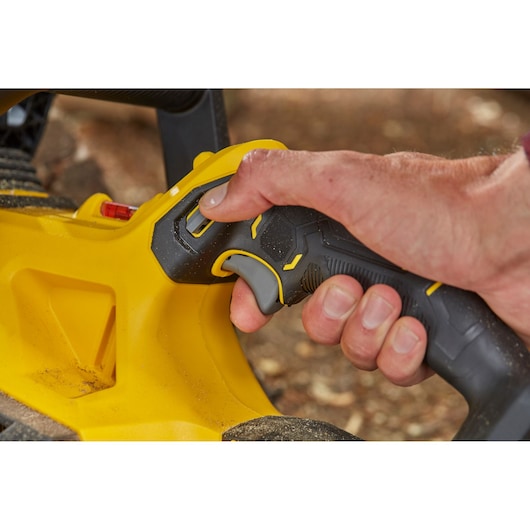 STANLEY SFMCCS630B close-up of black and yellow power tool handle with trigger, hand gripping.