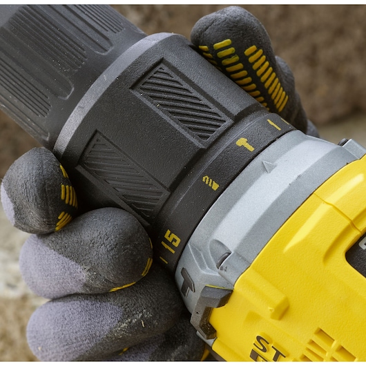 Close-up photo of STANLEY SFMCD715M2K drill showing hand adjusting torque settings, photography category.