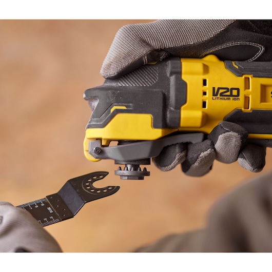 STANLEY SFMCE510B oscillating tool close-up with gloved hand attaching blade.
