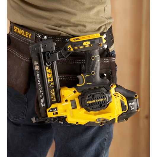 Photo of STANLEY SFMCN618B-XJ 18V nailer in yellow and black, holstered on a worker’s tool belt.
