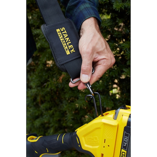 STANLEY SFMCPH845M1 photography of black FATMAX strap hooked onto yellow power tool outdoors.