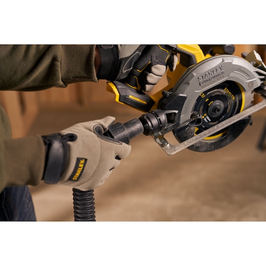 Stanley SFMCS550M2K circular saw with dust hose attached, shown in a close-up photography during use.