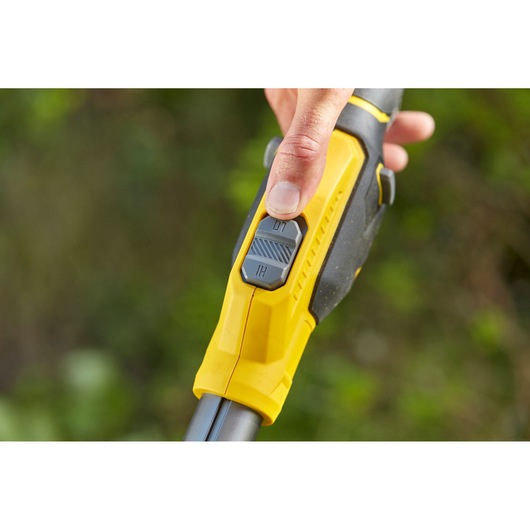 Photo of STANLEY SFMCSTB933M grass trimmer handle close-up showing yellow grip and dual-speed control switch.