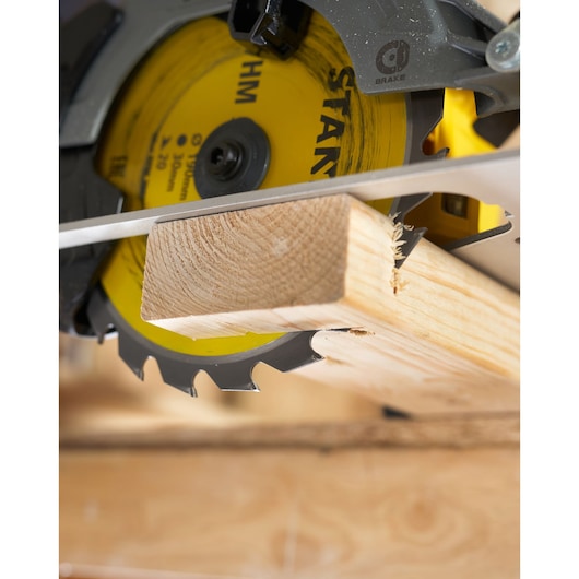 Photo of STANLEY STA13030 circular saw cutting wood plank, close-up on yellow blade and clean cut.