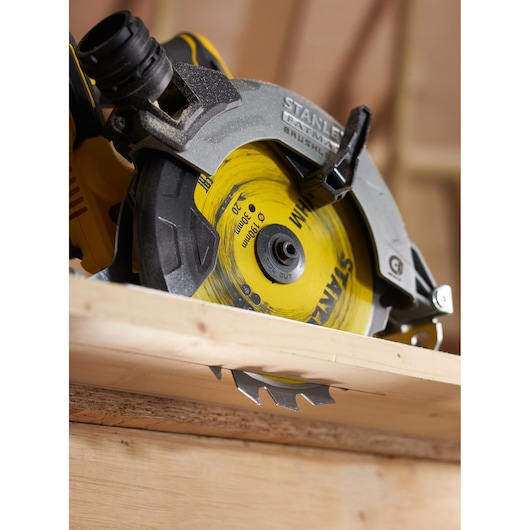 STANLEY STA13030 circular saw close-up cutting wood, showing yellow and black blade and guard.