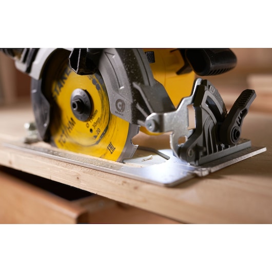 STANLEY STA13030 circular saw close-up cutting wood, yellow blade, photography.
