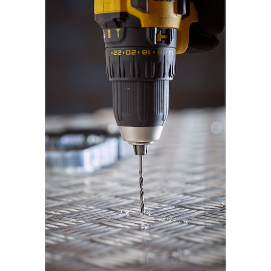 STANLEY STA88553 drill close-up drilling into metal surface, black and yellow power tool photography.