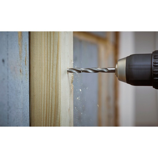 STANLEY STA88553 drill bit creating a hole in wood, side view, with wood shavings visible.