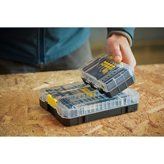 Photo of STANLEY STA88557 organizer box set with clear lids, shown in use on a wooden workbench.