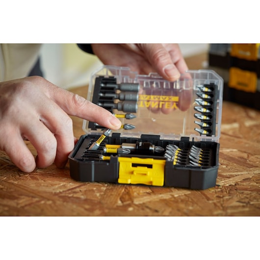 STANLEY STA88557 screwdriver bit set in black/yellow case, open on wood surface, bits organized inside.