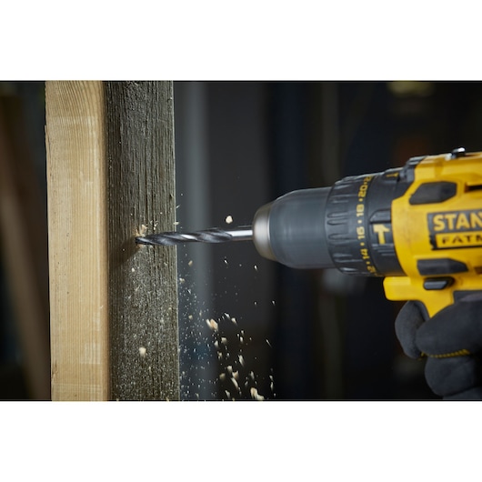 Photo of STANLEY STA88561 drill in use, drilling into wood with sawdust flying.