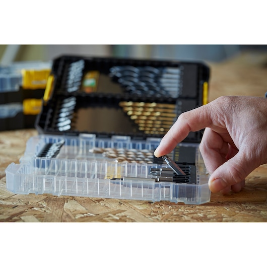 STANLEY STA88563 drill bit set in transparent plastic case, hand selecting bit, photography close-up.