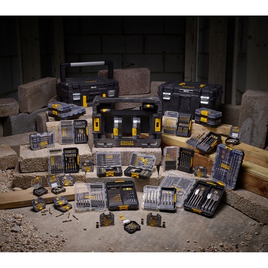 Stanley STA88565 drill and bit sets displayed with black toolboxes and cases on construction site.