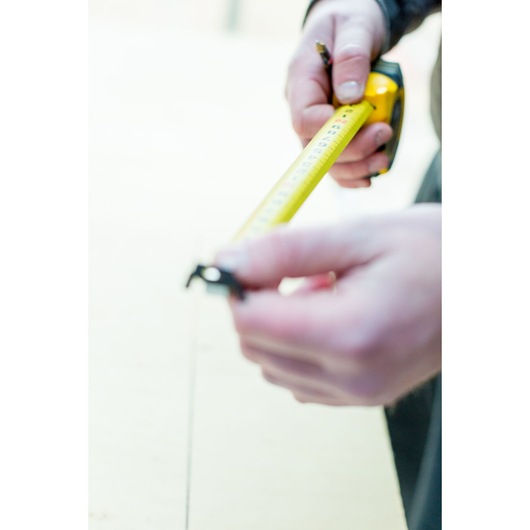 STANLEY STHT0-36118 tape measure held by hands, photography, yellow tape extended.