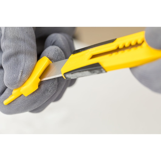 Photo of STANLEY STHT10345-0 utility knife with yellow and black handle, held with gloves.