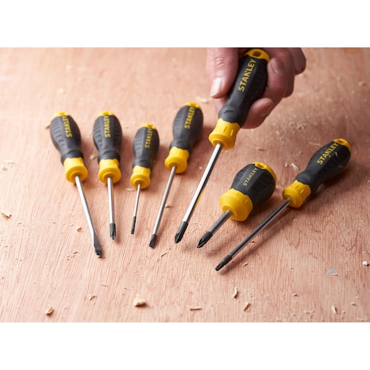 STANLEY STHT16163-0 screwdriver set with yellow and black handles, six pieces shown on a wooden surface.