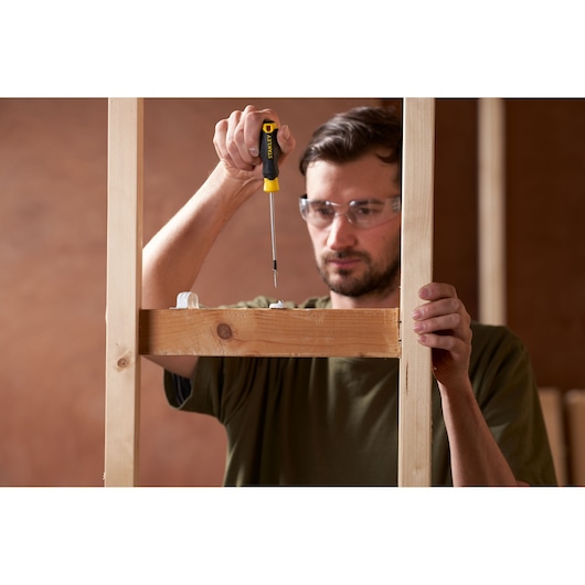 Photo of STANLEY STHT16195-0 screwdriver being used to assemble a wooden frame, close-up view.