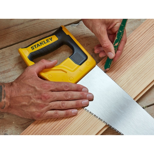 Photo of STANLEY STHT20355-1 hand saw with yellow handle, used for marking wood on a workbench.