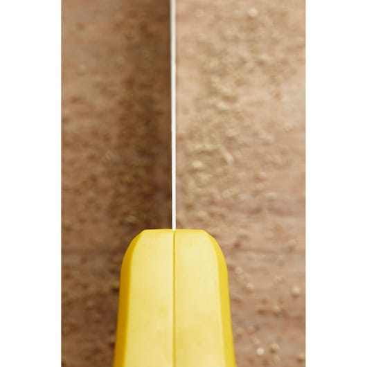 STANLEY STHT20369-1 close-up photo of yellow hand saw handle and blade on wood surface.