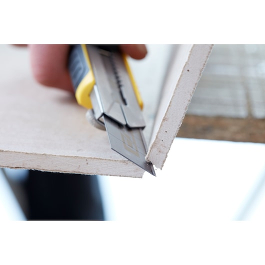 STANLEY STHT3-11825 utility knife cutting drywall, close-up photo, Photography category.