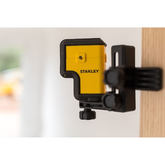 Photo of STANLEY STHT77503-1 laser level mounted on a black bracket, yellow and black design.