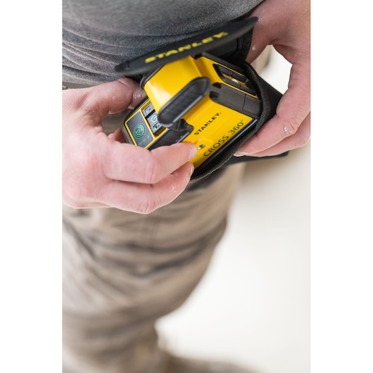 STANLEY STHT77594-1 yellow Cross 360 laser level held in hand with protective pouch.