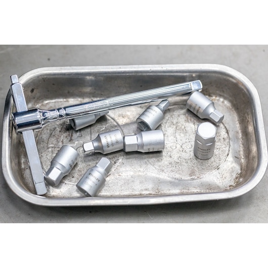 STANLEY STHT81574-0 socket set with ratchet wrench, silver finish, in metal tray, close-up photo.