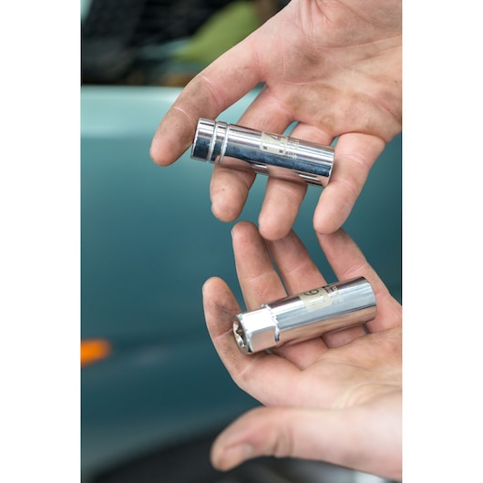 Photo of two STANLEY STHT81583-0 chrome sockets held in hands with visible car background.