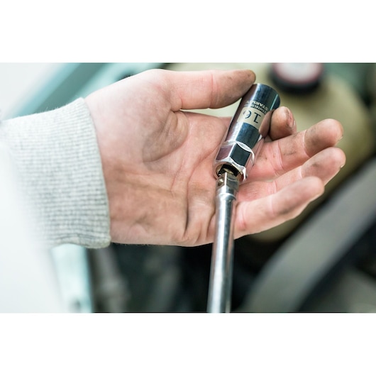 Photo of STANLEY STHT81583-0 socket wrench in a person's hand, chrome finish, close-up view.