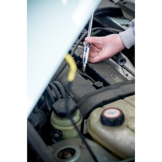 STANLEY STHT81583-0 test screwdriver used on car engine, close-up photo of tool in automotive setting.