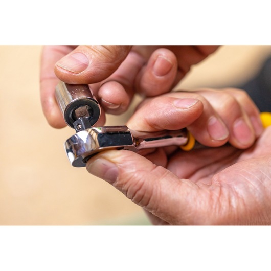STANLEY STMT82666-0 ratchet wrench and socket in close-up, held in hands, photography.